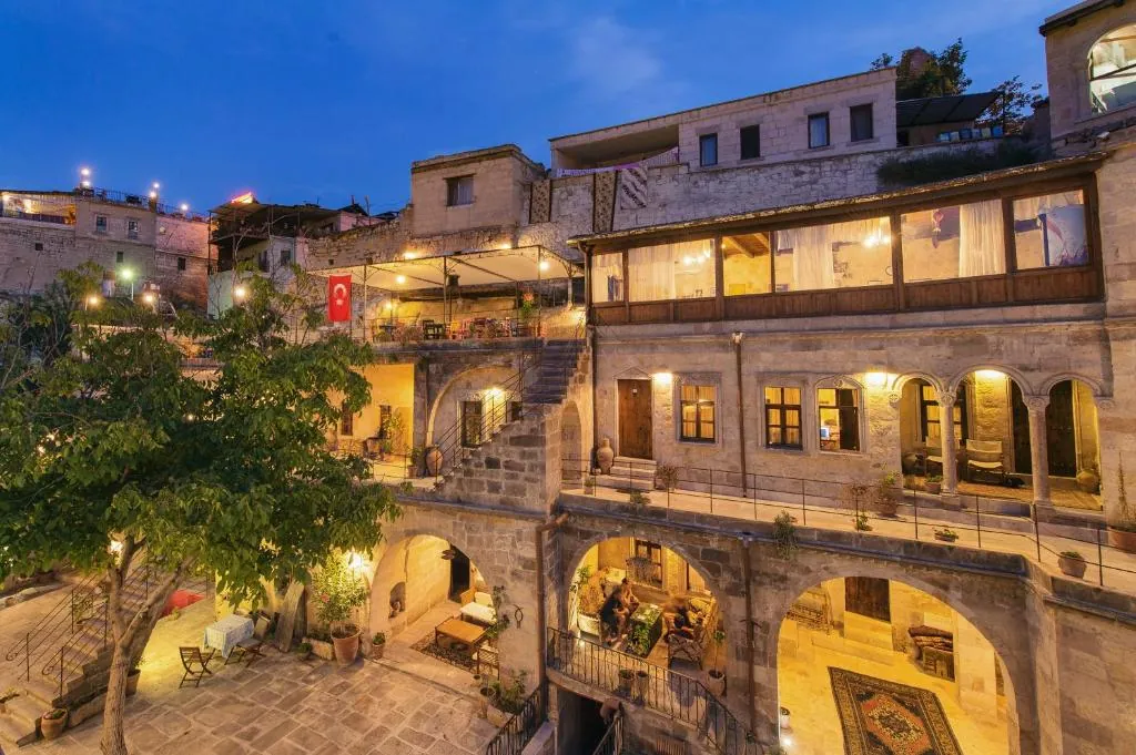 Century Cave Hotel’s illuminated stone facade and courtyard at dusk
